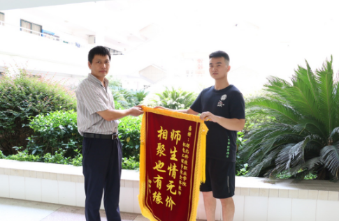 杨坤鹏将锦旗递交学院副院长汪超